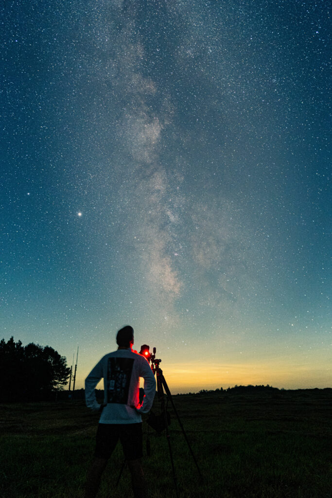 Man with telescope looking at galaxy
